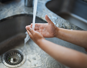 Image showing Child, hands and washing for clean hygiene, health and wellness with water in the kitchen. Hand of kid rinsing or cleaning with soap under running tap in basin to remove bacteria, virus or germs