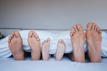 Image showing Family feet, bed and home together with love, support and bonding in the morning. Sleep, bedroom and house with a mother, dad and child relax under a blanket with a foot from parents and kid