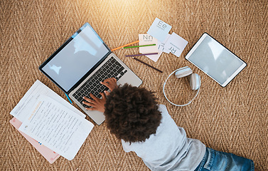 Image showing Online education, laptop and child on floor for e learning, language translation and typing on kids website. Kid relax on carpet with computer, headphones and digital tech for home development above