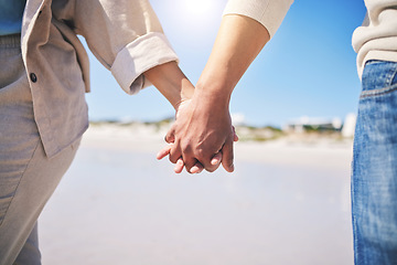 Image showing Holding hands, love and a couple walking on the beach for romance, support or a date. Content, vacation and a man and woman with affection on a walk at the ocean for commitment and trust together