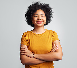 Image showing Happy, woman and arms crossed for portrait in studio, white background and backdrop. Young female model, smile and natural curly afro hair with positive personality, gen z and girl of South Africa