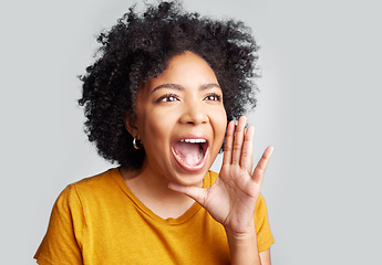 Image showing Young woman and shouting or holding hand near wide open mouth or calling someone and yelling information on grey studio background. Loud, announcement and girl screaming interesting news