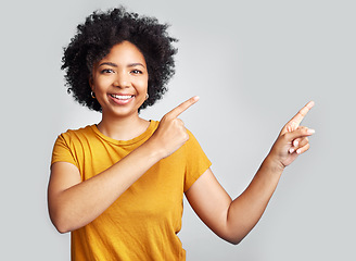 Image showing Happy woman, portrait and pointing to advertising at white background, information offer and brand coming soon. Young female model gesture to sales announcement, commercial promotion and presentation