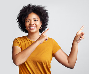 Image showing Portrait of happy woman, advertising and pointing to studio offer, information and brand coming soon. African female model gesture to announcement, sales promotion or presentation on white background