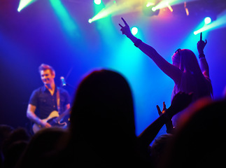 Image showing Audience, neon lights or people dancing at music festival from back, lighting at live concert night event. Dance, fun or group of excited fans in arena at rock band performance or crowd at party