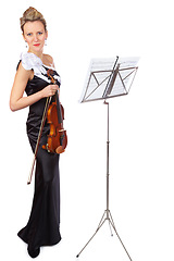 Image showing Art, violin and portrait of woman in studio, professional orchestra musician on white background with sheet music. Creativity, classical performance and concert violinist holding instrument in dress.