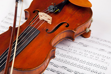 Image showing Sheet, music and classical with violin on paper for orchestra, vintage and antique instrument. Notes, retro art and culture with closeup of wooden fiddle for symphony, sound and theatre performance