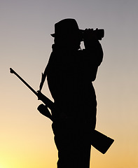 Image showing Hunting at sunset, man with gun and binoculars in nature to hunt game for sport on safari adventure. Sky, silhouette and hunter with rifle, search and setting sun for shooting hobby on summer evening