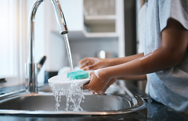 Image showing Hands, sink and washing dishes with a person in the kitchen of a home to wash a plate for hygiene. Water, bacteria and soap with an adult cleaning porcelain crockery in a house to clean for housework