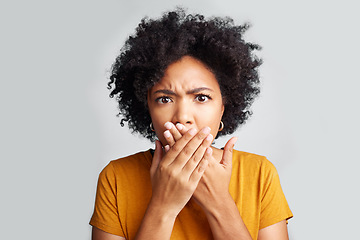 Image showing Portrait, young woman and shocked with closed mouth or crossed hands and wide opened eyes on gray background. Face, fear and girl holding secret or astonished with bad news or information