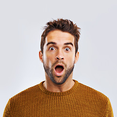 Image showing Shock, surprise and portrait of a man in a studio with an amazed facial expression or attitude. Shocked, amazing news and male model with a wtf, omg or wow face gesture isolated. by white background.