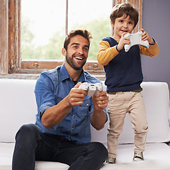 Image showing Love, father and son on a couch, online game and relax at home, playing or carefree in the lounge. Family, dad or boy with parent, kid or male child with controller, gamers or bonding with connection