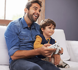 Image showing Happy, father and son with controller, video game and happiness at home, bonding and quality time. Family, dad or male child on a couch, loving or playing online games, joy and technology in a lounge