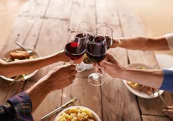 Image showing Hands, group and wine glass for toast at table for celebration, food and friends at lunch event. People, together and celebrate with alcohol, glasses and support at party, dinner and family home