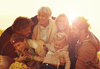 Image showing Happy, love and big family in nature at sunset hugging, bonding and spending quality time together. Happiness, smile and children posing with their parents and grandparents in outdoor field at dusk.