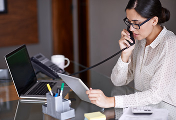 Image showing Telephone, tablet and businesswoman on a call in the office doing research on the internet. Technology, landline and professional female employee working on corporate project with mobile in workplace
