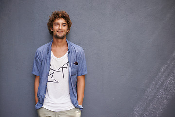 Image showing Happy, smile and portrait of a man by a wall with mockup space with a casual, cool and stylish outfit. Happiness, positive and handsome male model with trendy style or fashion with gray background.