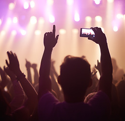 Image showing Fan, phone filming and band on stage with excited audience, lighting colors and music performance on video. Smartphone screen, photography and festival crowd at night and concert, event or party