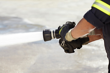 Image showing Hands, spray and nozzle for water, firefighter and help in emergency, brave or stop inferno in uniform. Fireman, fire hose and fearless on mission to rescue, health and safety service at job outdoor