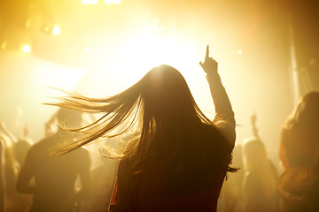 Image showing Dance, music and back of woman at a concert, disco event or psychedelic trance festival. Night, energy and female person dancing or moving to a song with a yellow light at techno night club or party.