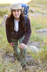 Image showing Woman, hiking portrait and smile on mountain to start adventure, journey or fitness with backpack in nature. Girl hiker, walking or field with happiness for exercise in countryside, summer or outdoor