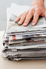 Image showing Newspaper, sustainability and hand of man on stack for recycling, environment and resources. Eco friendly, waste and news with closeup of person and paper for responsibility, garbage and conservation