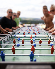 Image showing Friends playing with a foosball at a party for competition, fun skill or sports event. Celebration, activity and group of people enjoying a football table game or match for a friendly championship.