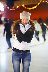 Image showing Woman, ice rink and portrait on cold night with self hug, training and exercise on winter holiday. Young girl, skate and freezing body with warm clothes for mistake, outdoor and regret on vacation