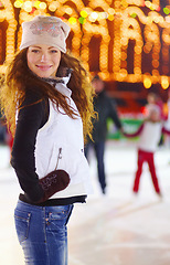 Image showing Woman, ice skater and night in portrait with smile for workout, training and exercise on winter holiday. Girl, skating rink and happiness for sport, skate or fitness with excited face for lifestyle