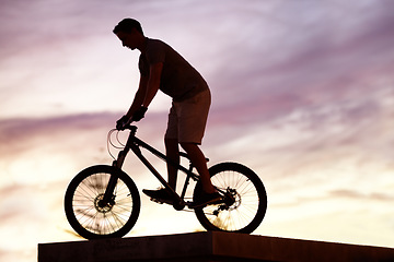 Image showing Silhouette, sunset and cycling with man on bicycle for sports, adventure and fitness. Action, exercise and health with male cyclist riding on bmx bike for journey, urban or carbon neutral with mockup