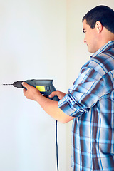 Image showing Wall drill, home and man with renovation, construction work or house improvement for maintenance, repair or builder project. Contractor, handyman or male technician with electric tools for drilling