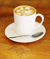 Image showing Latte art, coffee and drink on table in cafe, closeup of hot beverage and artistic heart design with milk foam. Cappuccino, espresso and creative pattern on caffeine liquid brew in a cup on a plate