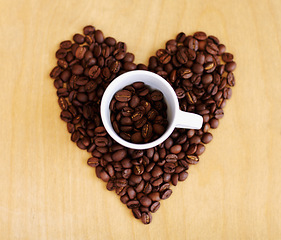 Image showing Heart, roasted coffee beans and cafe industry with love icon or emoji for marketing and advertising. Above wooden table or background with grain shape as drink, espresso or caffeine ingredient