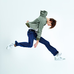 Image showing Young man, leaping and fashion jumping in style, excitement or hip against a studio background. Happy male model in air jump with stylish casual clothing, jacket and jeans isolated on mockup