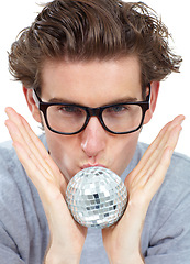 Image showing Disco ball, kiss and portrait of a man with celebration, party and clubbing decoration in a studio. Isolated, white background and young male person with model face kissing a small partying deco