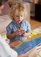 Image showing Father with boy kid, reading book for education and development, spending quality time together at home. Family, teaching and learning with man and child bonding, picture story with toys for growth