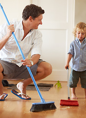 Image showing Man is cleaning with boy child, sweeping with broom and help with mess on floor while at home together. Hygiene, chores and house work with man teaching kid to sweep and helping with crumbs on ground