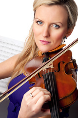 Image showing Sheet music, violin and portrait of woman in studio, professional orchestra musician on white background. Art, musical creativity and classical performance, face of concert violinist with instrument.