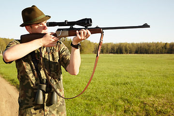 Image showing Hunter, gun and man in nature on a Africa safari for animal shooting with a weapon on vacation. Hunting sport, male person and target hunt practise of a traveler in camouflage looking at a scope