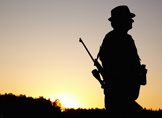 Image showing Hunting at sunset, man with rifle and mockup in nature to hunt game for sport hobby on safari adventure. African sky, silhouette and mock up space, hunter with gun in bush and evening setting sun.