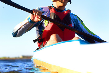 Image showing Fitness, kayak and a man rowing in the water of a river alone outdoor in nature during summer adventure. Sports, exercise and training with a male athlete in a canoe to row using paddles outside