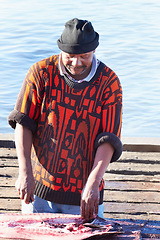 Image showing Fishes, fisherman and man cutting, gutting or prepare food, meat or seafood for sales trade at fish market. Ocean fishing harbour, sushi ingredients and male person cleaning raw tuna with knife