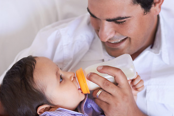 Image showing Baby, feeding and dad with child at home with a bottle of milk with happiness with kids. Family, young child and drink for growth and development with a father feeling proud and happy in a house