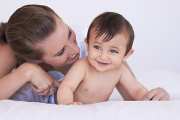 Image showing Happy, bedroom and relax baby with mom for morning rest, childhood and enjoy fun bonding time together. Child growth, family happiness and playing mother, mama or woman tickle infant toddler on bed