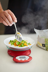 Image showing Scale, food and man with vegetables in kitchen to measure portion for calories, nutrition and balance diet. Cooking, hungry and hands of male person weigh healthy meal for lunch, dinner and supper