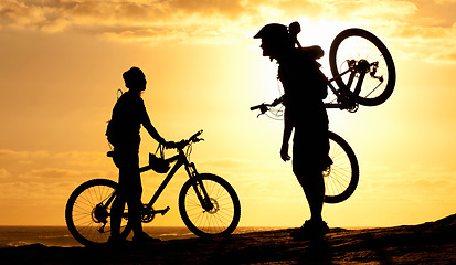 Image showing Sunset, silhouette and couple with bike at beach for relax, fitness and summer break. Travel, vacation and training with man and woman with bicycle on coastline for cycling, bonding and wellness