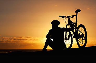 Image showing Sunset, silhouette and bike with man at beach for relax, fitness and vacation trip. Travel, cycling and sky mockup with male cyclist and bicycle on coastline for training, peace and sports hobby