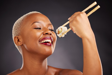 Image showing Face, eating and woman with sushi and chopsticks in studio for healthy food or beauty. Black female model with makeup on a dark background for wellness glow, fish diet or seafood with nutrition