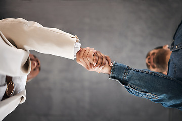 Image showing Business people, handshake and meeting in partnership, teamwork or trust for unity below at office. Low angle of employees shaking hands for introduction or greeting in agreement or deal at workplace