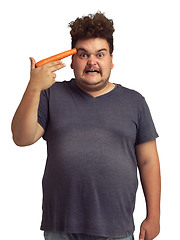 Image showing Carrot gun, plus size and man in portrait isolated on a transparent png background. Vegetables, weapon and angry person upset for diet, nutrition and vitamins, food and health, wellness and funny.